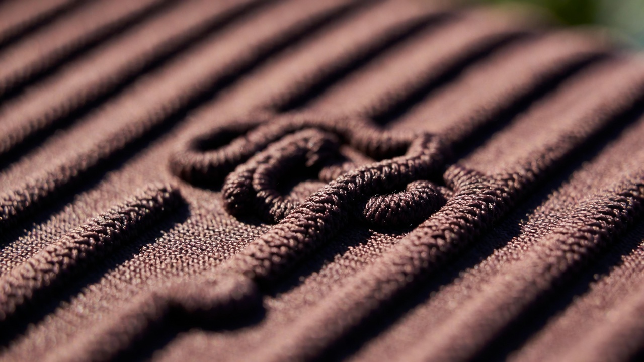 Detailed close-up of high-GSM ribbed 'Bombon' swimwear fabric showing the quality construction associated with Kylie Jones style.